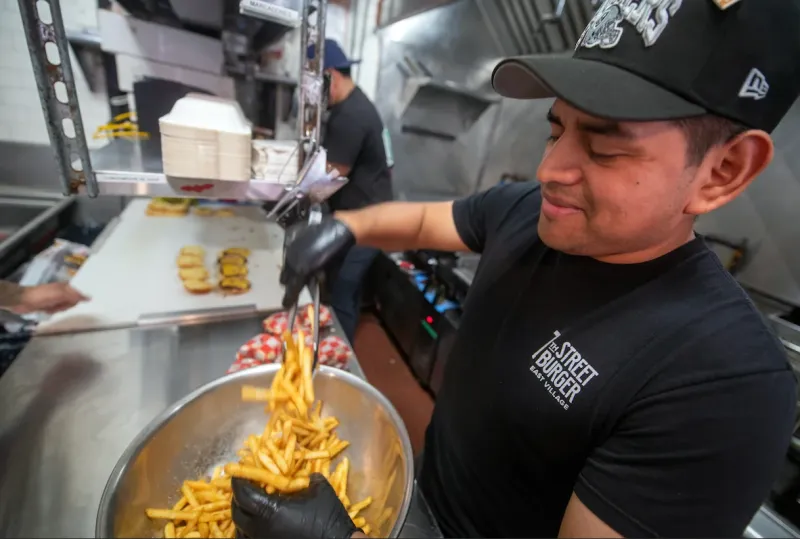 7th Street Burger employee preparing fries during service