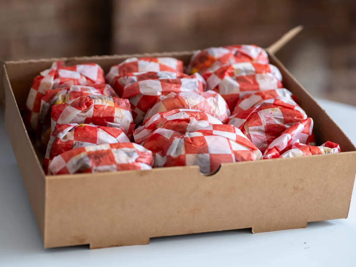 7th Street Burger catering box filled with individually wrapped cheeseburgers