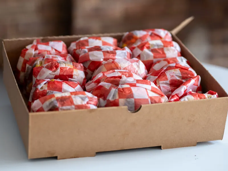 7th Street Burger catering box filled with individually wrapped cheeseburgers